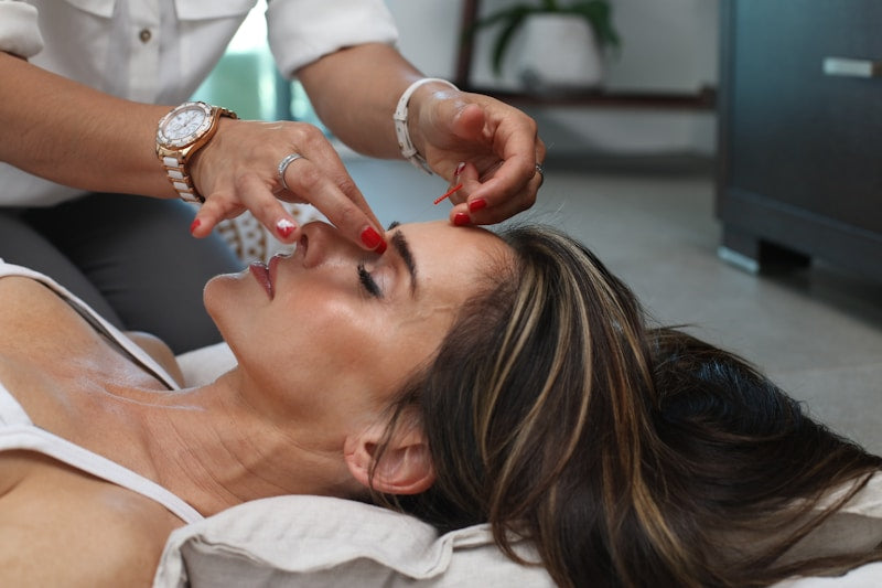 Woman using microcurrent face lift device beauty ritual skincare