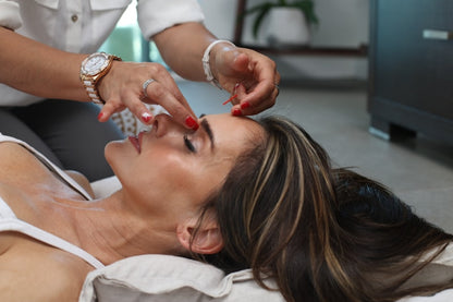 Woman using microcurrent face lift device beauty ritual skincare