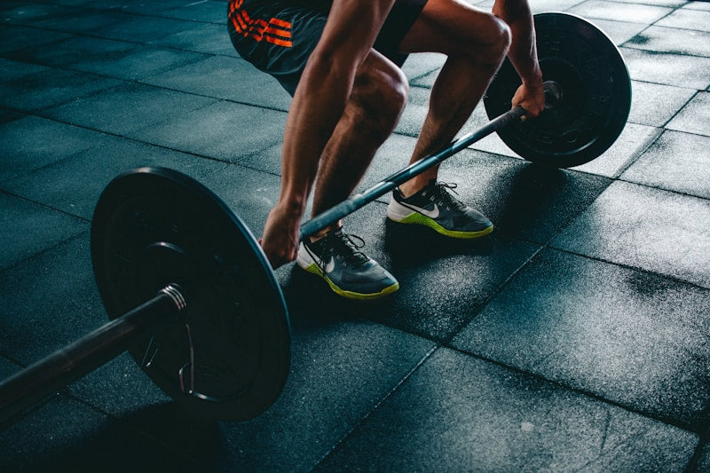 Athlete foam rolling IT band on exercise mat post-workout recovery routine