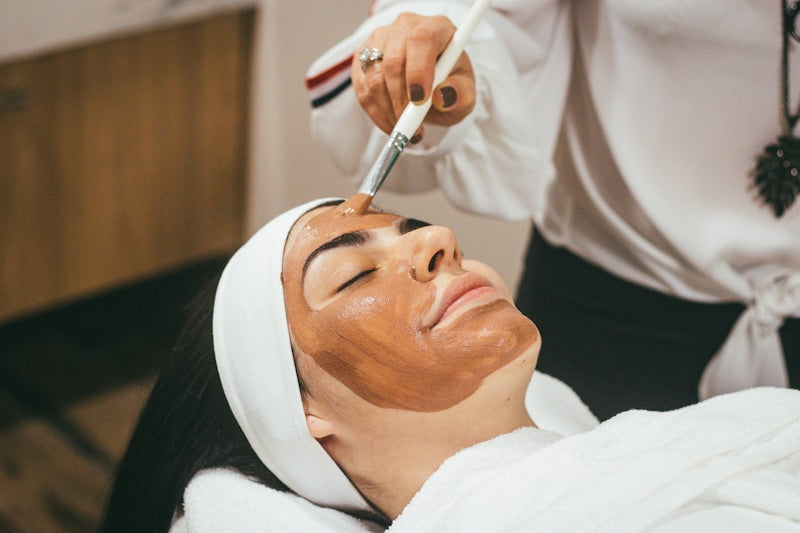 Woman wearing LED red light therapy face mask skincare routine at home