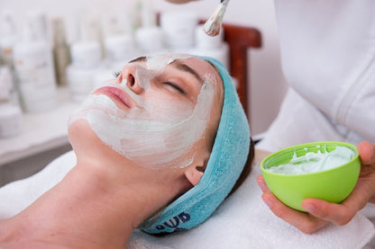 Woman using electric facial cleansing brush for deep pore skincare routine